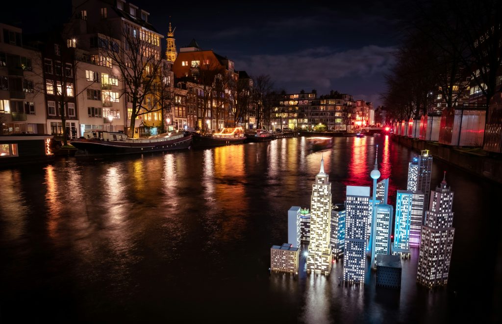 Art installation in the form of illuminated buildings projected onto the canal during the Amsterdam Light Festival.