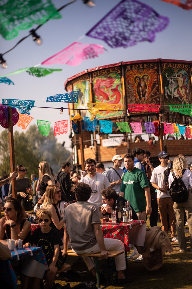 Personas disfrutando de De Rollende Keukens, rodeadas de colores vibrantes y un ambiente festivo en Westerpark.