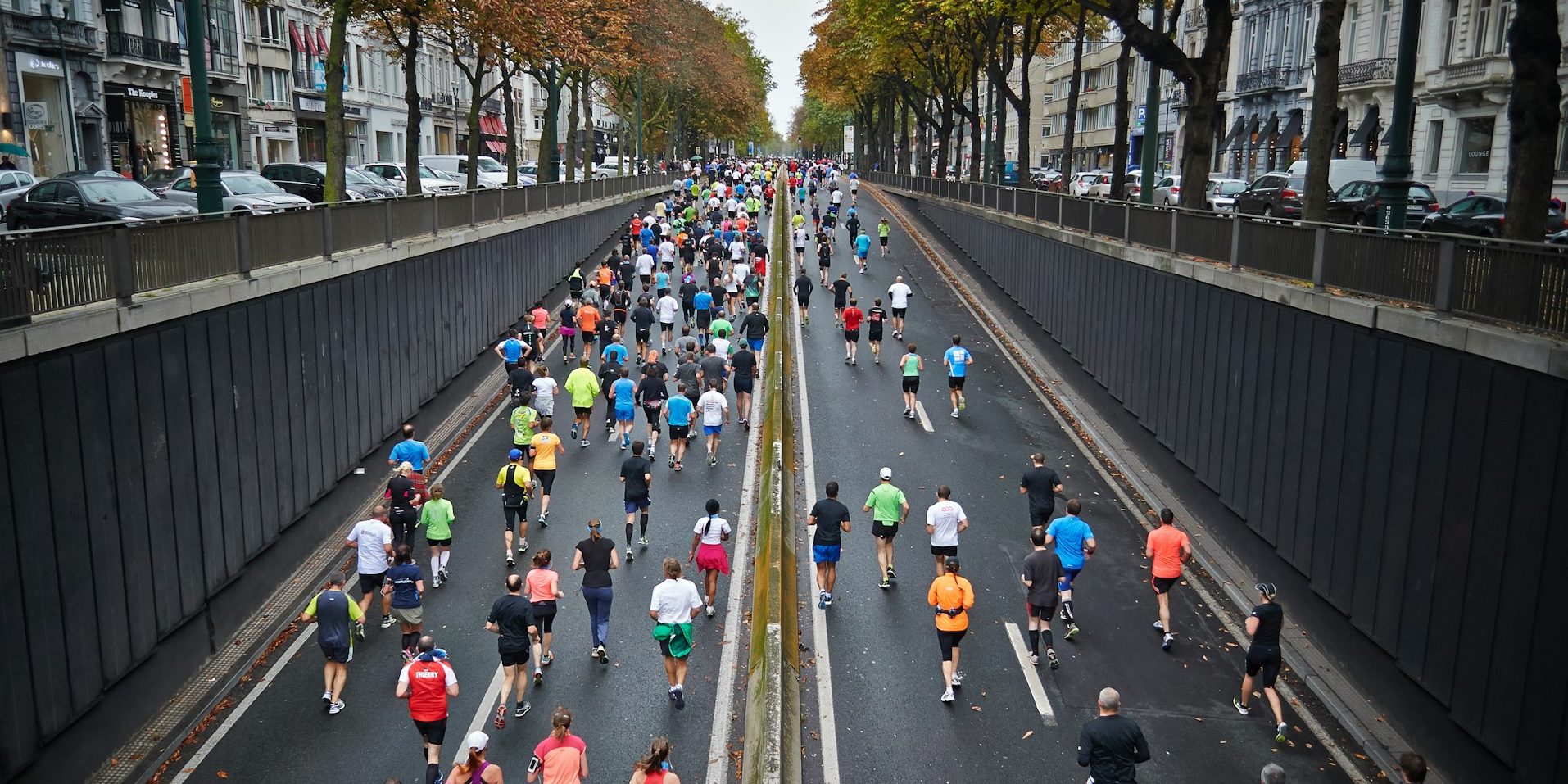 Corredores cruzando un puente icónico durante la maratón, rodeados de un ambiente vibrante y espectadores animando.