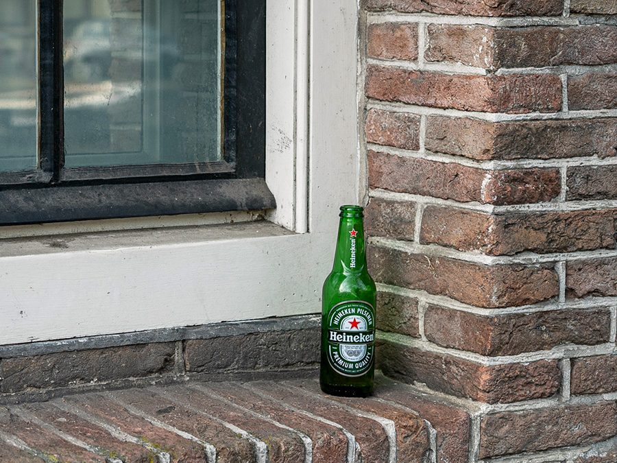 Botella de cerveza Heineken sobre el alféizar de una ventana tradicional en Ámsterdam.