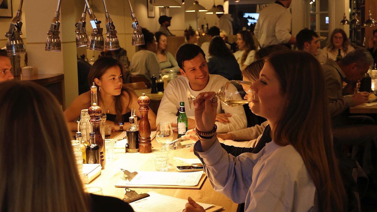 Interior de la Spaghetteria en el barrio De Pijp de Ámsterdam con mesas compartidas y ambiente informal.