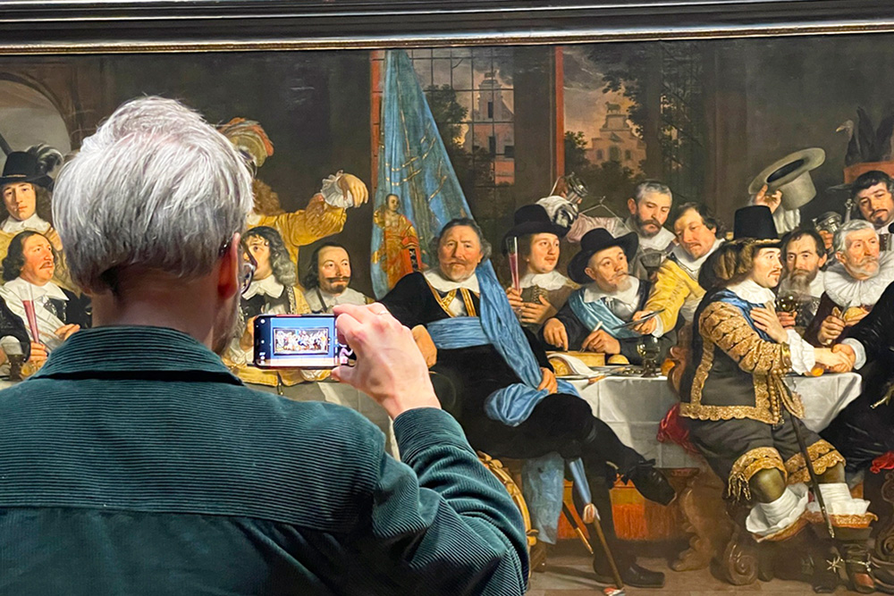 Hombre fotografiando una pintura de Rembrandt en una sala del Rijksmuseum de Ámsterdam.
