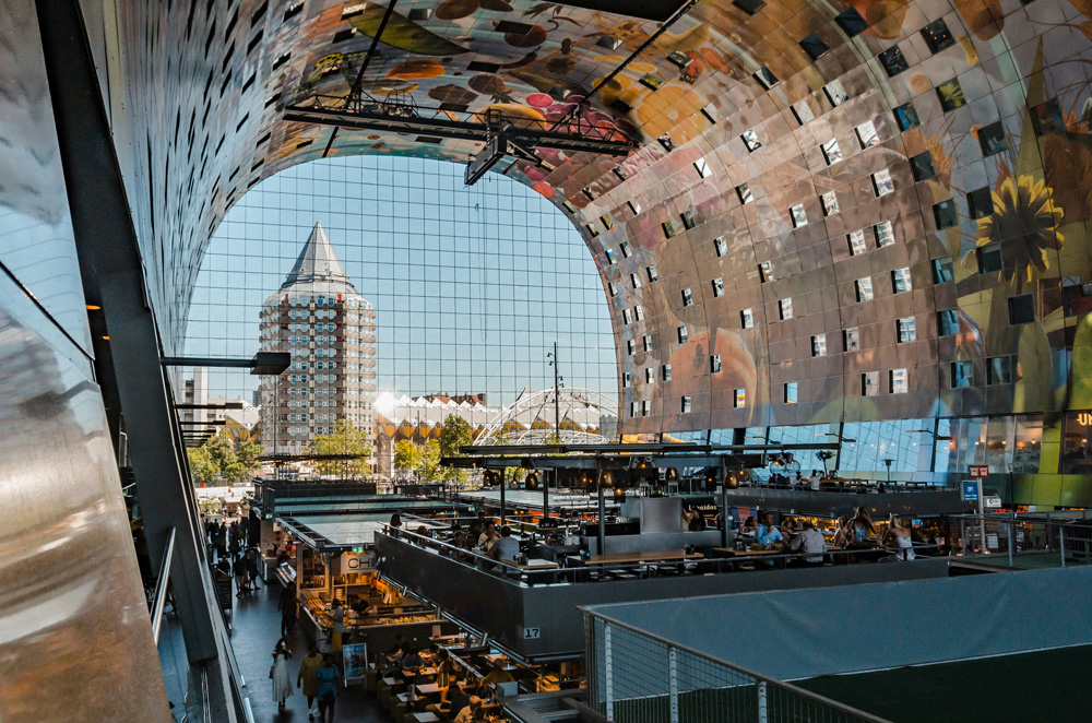 Puestos de comida dentro de la Markthal de Róterdam con su icónica bóveda decorada.