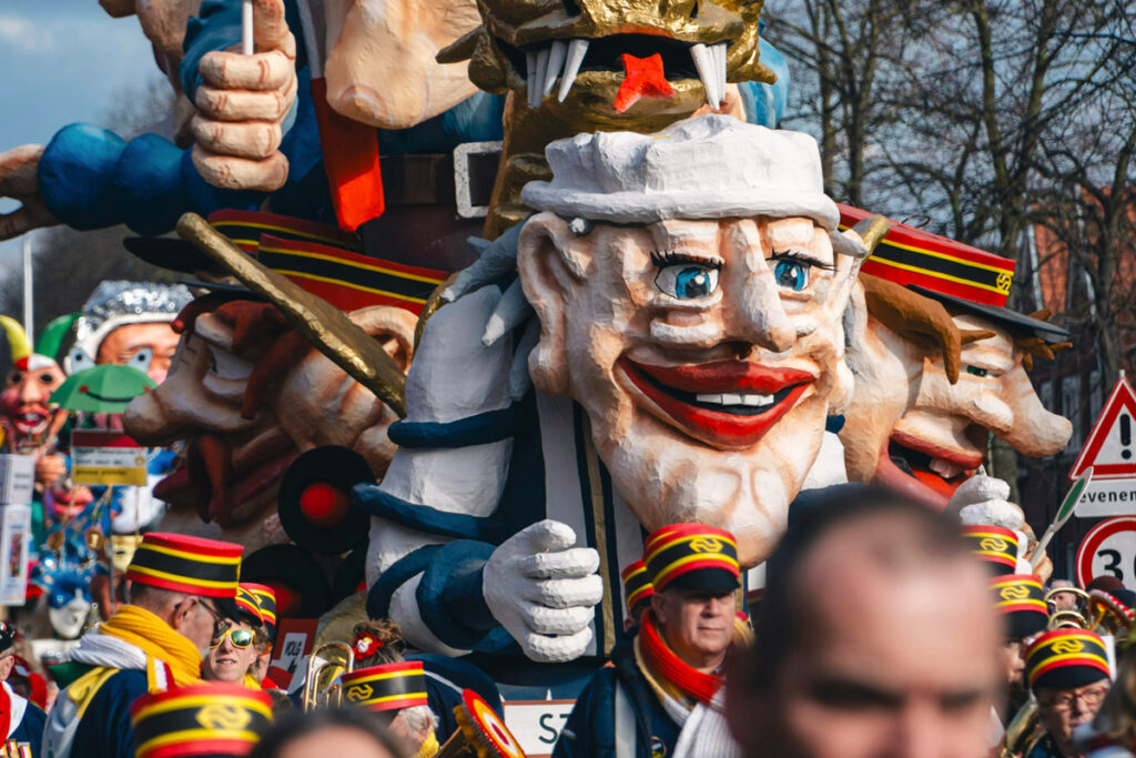 Carrozas coloridas durante el desfile de carnaval en Den Bosch, con disfraces y ambiente festivo.