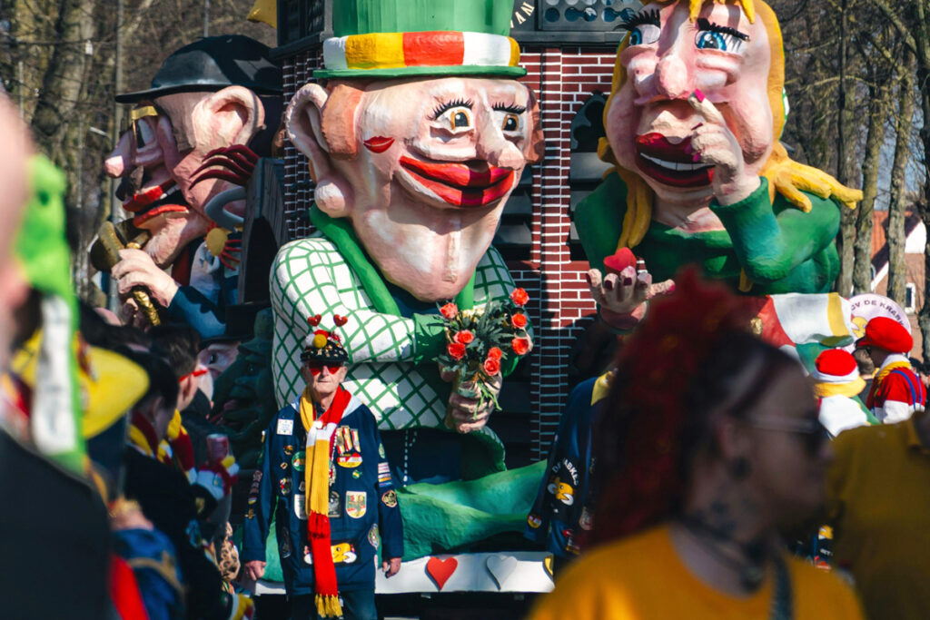 Carrozas coloridas durante el desfile de carnaval en Den Bosch, con disfraces y ambiente festivo.
