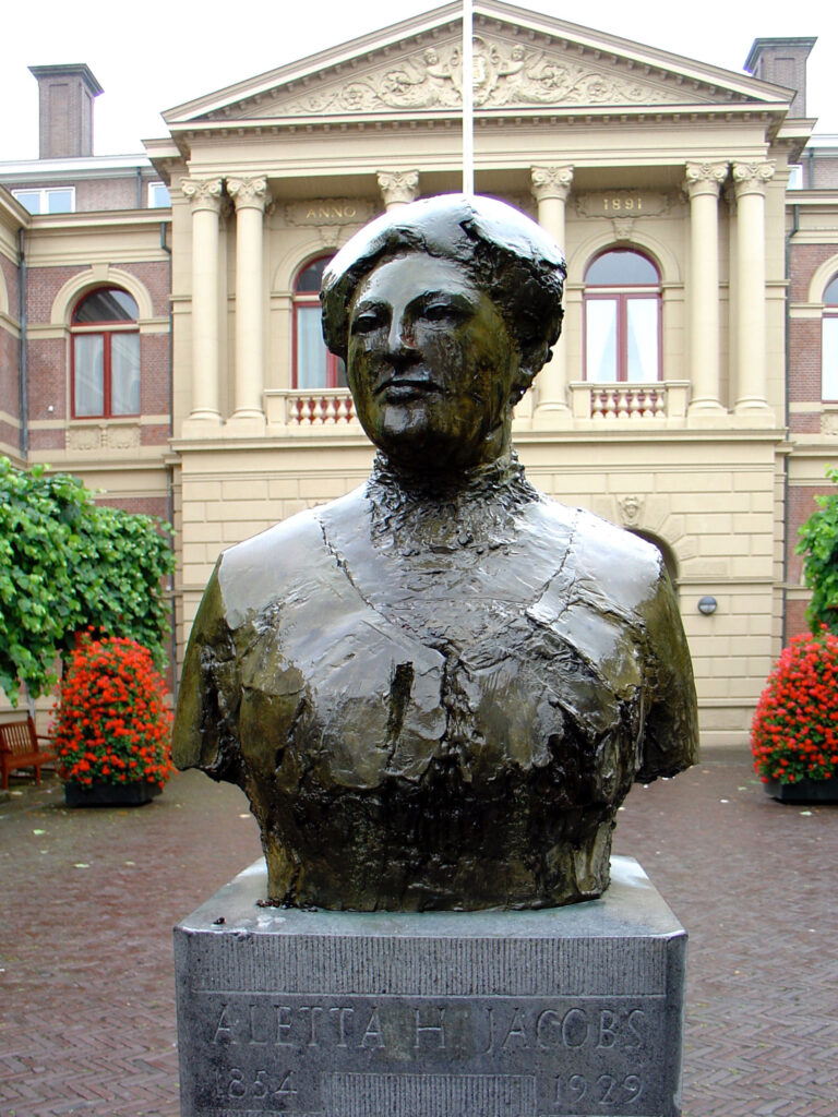 Busto de Aletta Jacobs frente al edificio Harmonie en Groningen, obra expuesta permanentemente en el espacio público.
