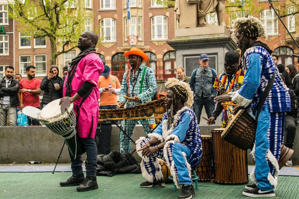 Grupo de músicos tradicionales de origen colonial tocando instrumentos de percusión durante el Día del Rey en Ámsterdam.