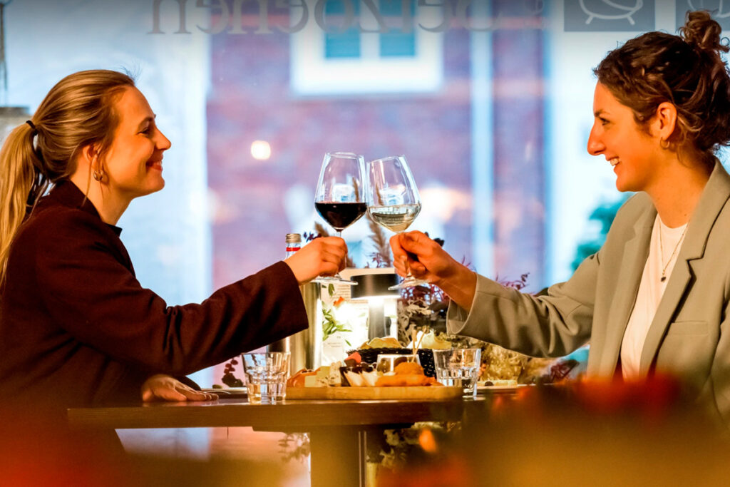 Dos mujeres brindan con copas en la terraza del restaurante De Vier Seizoenen en Lisse, durante un almuerzo de primavera cerca de Keukenhof.