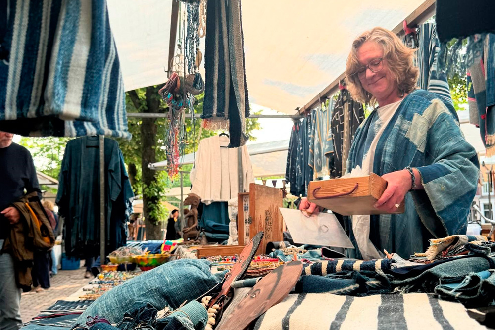 Vendedora en un puesto de telas y prendas en el mercado Noordermarkt de Ámsterdam.