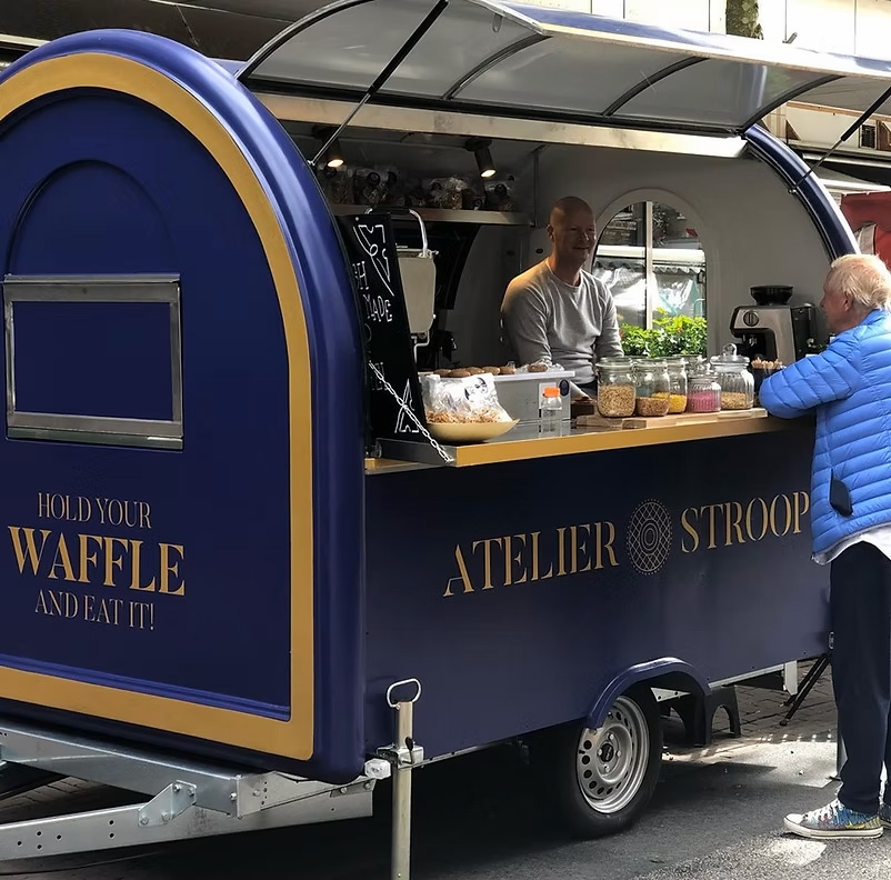 Puesto Atelier Stroop en Ten Katemarkt en Ámsterdam, con stroopwafels recién hechos en el mercado.
