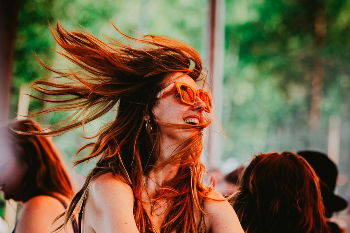 Chica disfrutando de un concierto en Best Kept Secret Festival, rodeada de bosque y naturaleza en verano en los Países Bajos.