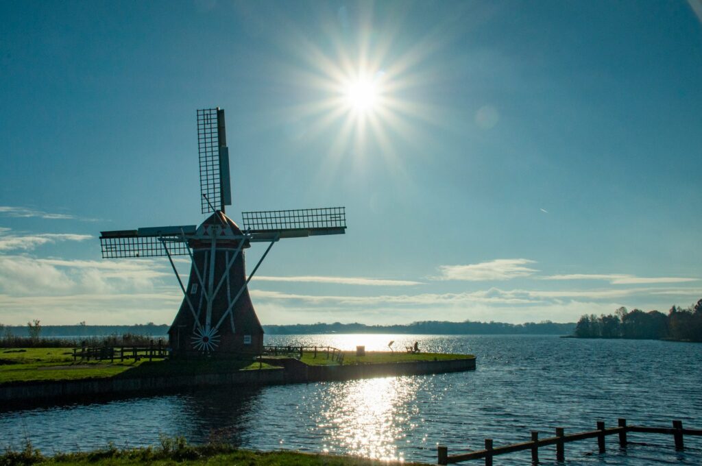 Molino de viento en Hoornsemeer, Groningen, junto a una zona de agua y paisaje abierto en el norte de los Países Bajos.