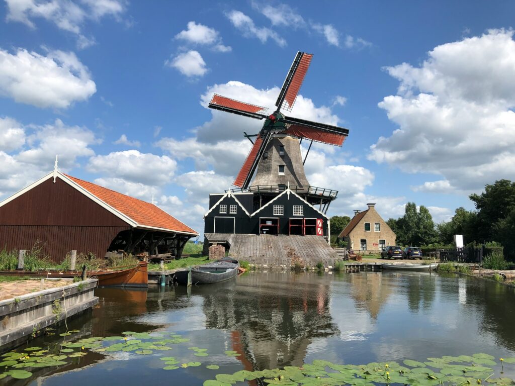 Molino de viento en IJlst, Frisia, junto al agua con casas tradicionales neerlandesas alrededor.