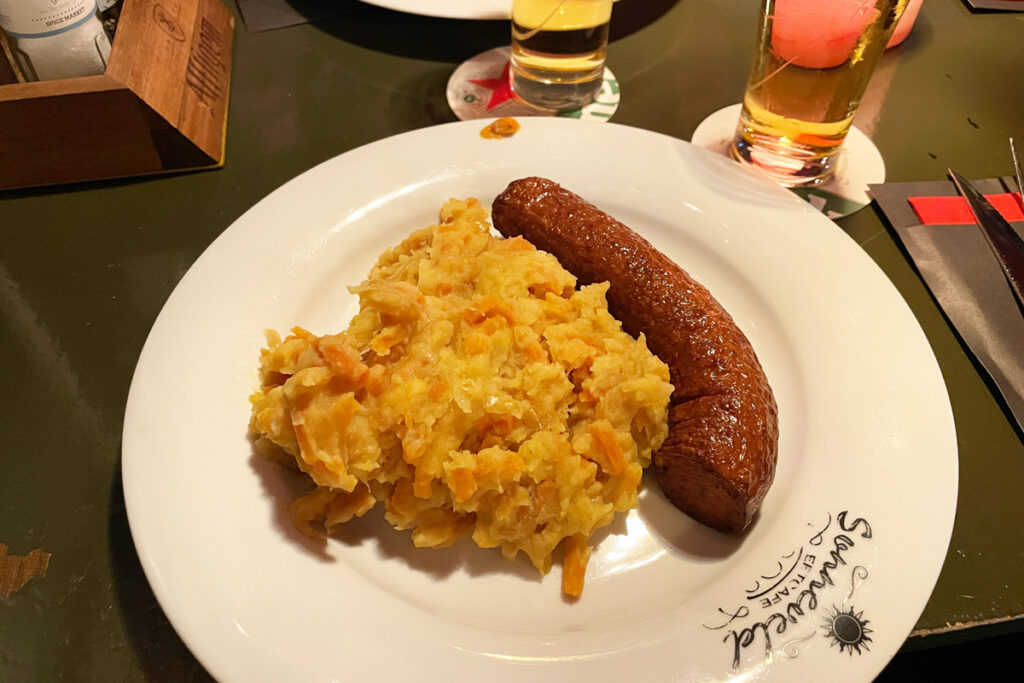 Plato tradicional de stamppot neerlandés con puré de patata, col rizada y salchicha ahumada.