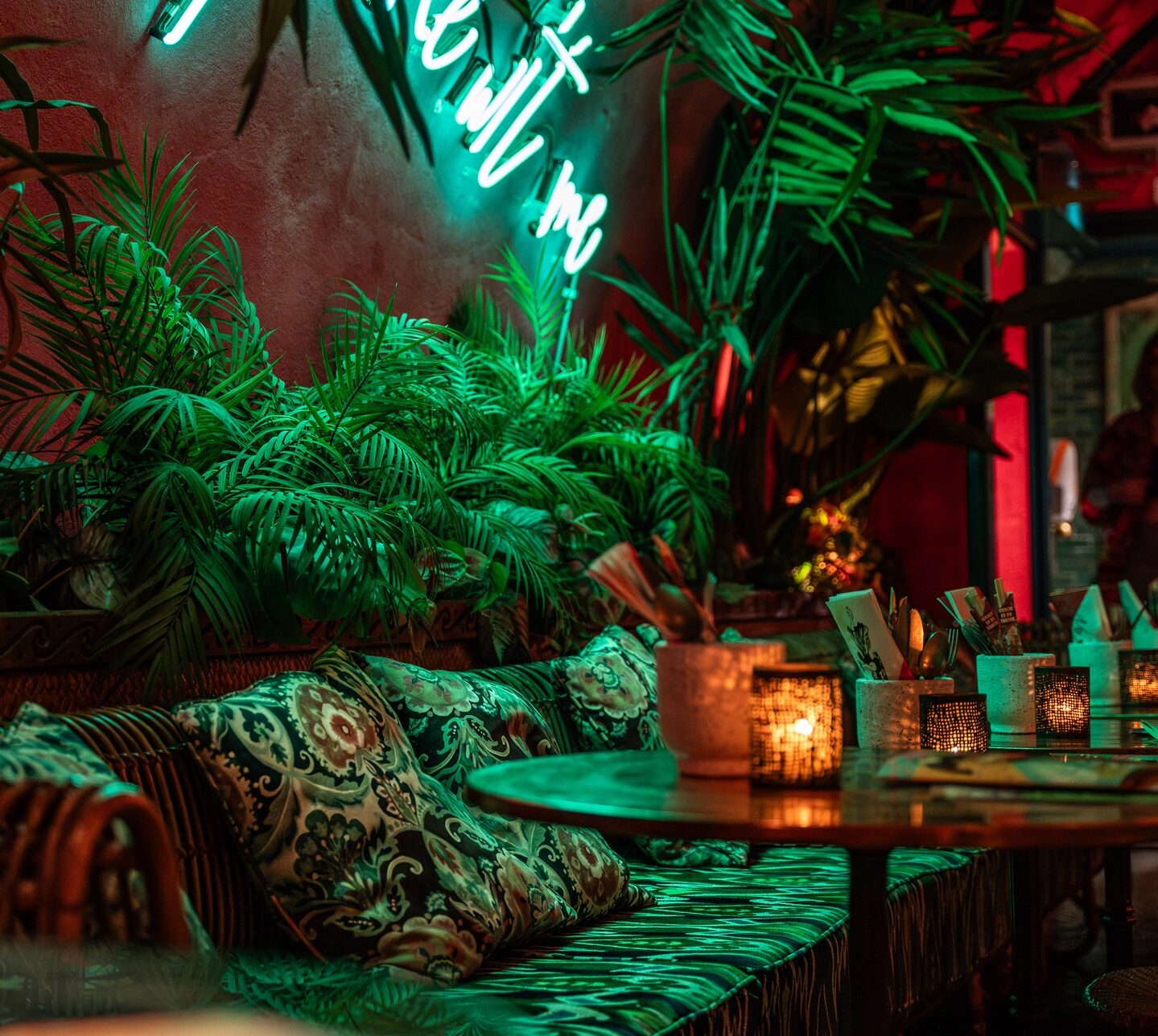 Interior de Rum Club en Utrecht con mesas, iluminación contrastada y decoración tropical durante la noche.