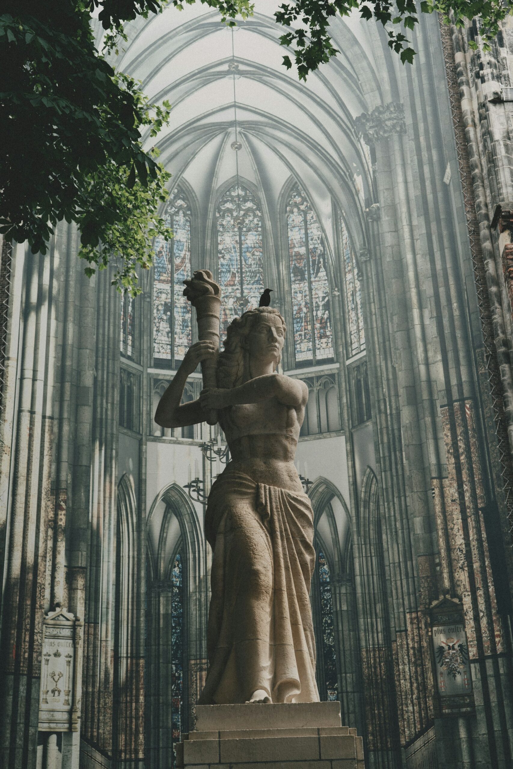 Estatua en el interior de la Catedral de San Martín de Utrecht rodeada por la arquitectura gótica del templo.