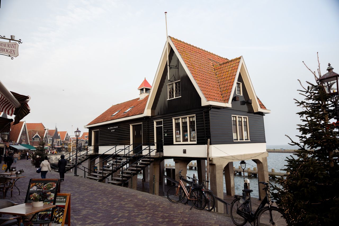 Zona peatonal del Haven de Volendam con terrazas, comercios y vistas al puerto histórico.