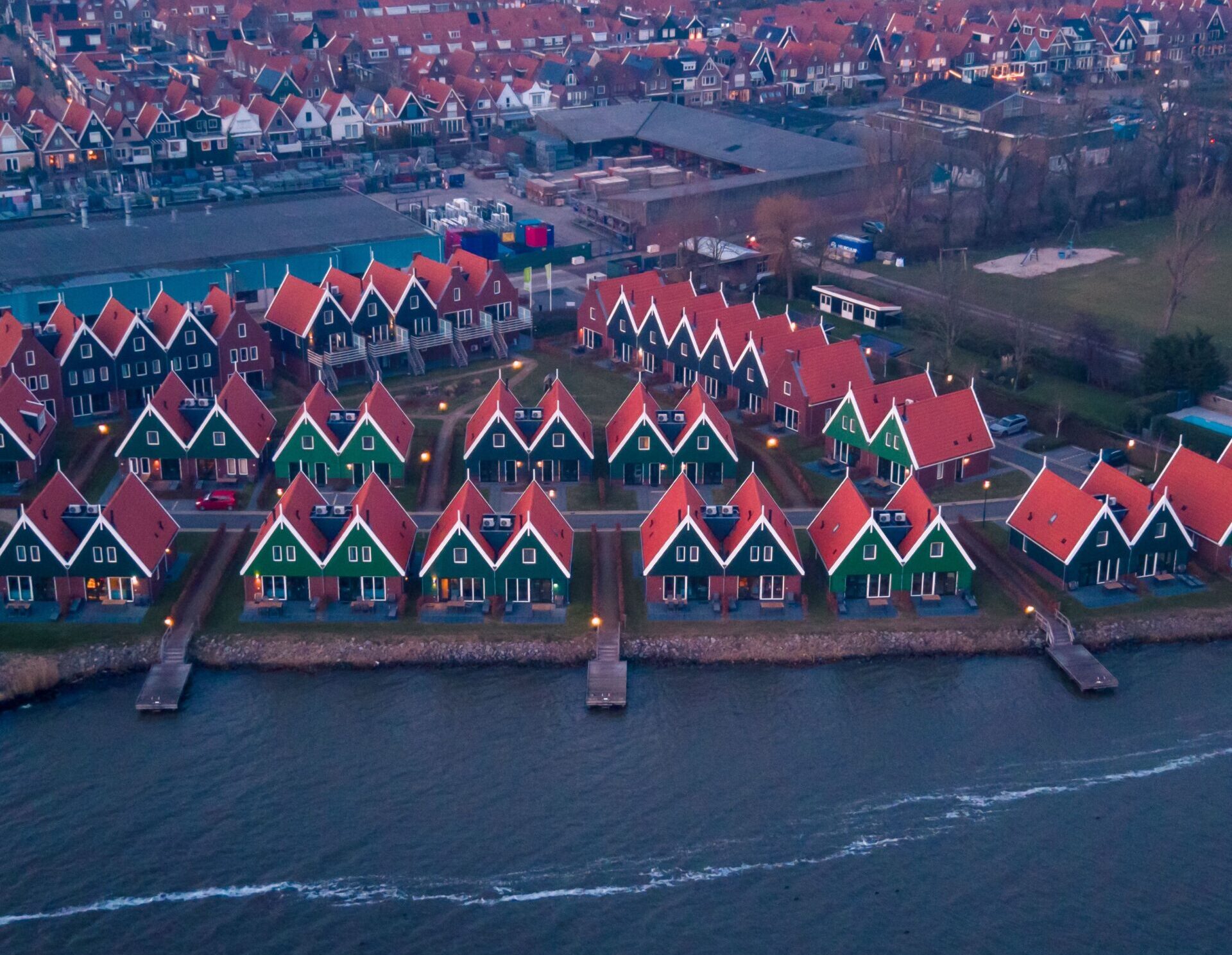 Vista aérea de Volendam con sus casas tradicionales de fachadas verdes y tejados naranjas junto al Markermeer.